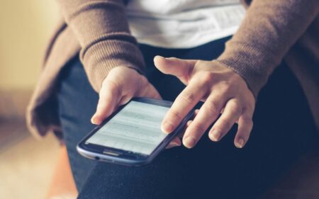 A woman holding her phone and activating Esimatic eSIM.